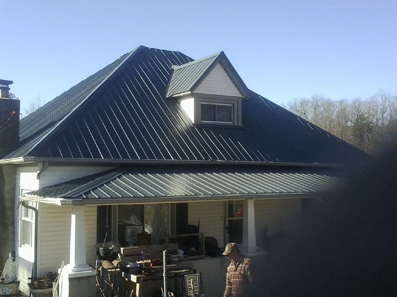 Dark blue standing seam metal roof with a dormer above a front porch in Washougal