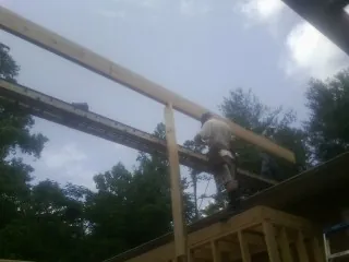 Carpenter setting a ridge beam over a new addition frame — Ice Dam Removal by Roofing Brothers in Washougal