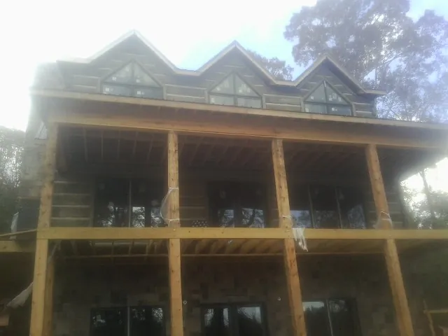 Dormers and porch framing on a large log home under construction — Roof Coating work by our crew in Washougal