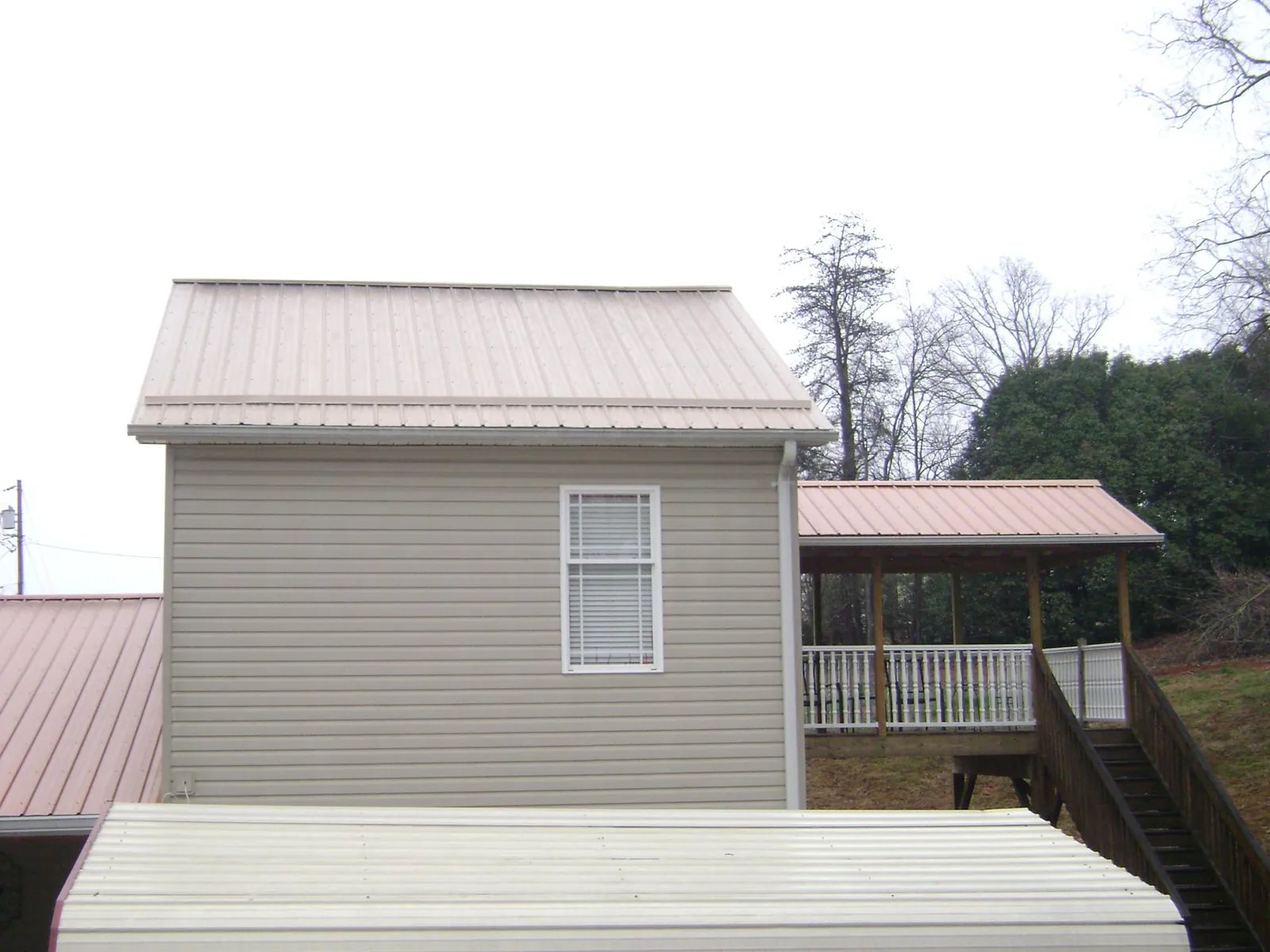 Tan metal roofs on a two story addition and attached porch, from a Roof Replacement job in Washougal